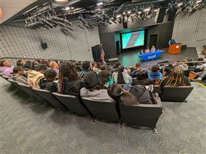 students sit in the DCCC auditorium during a presentation