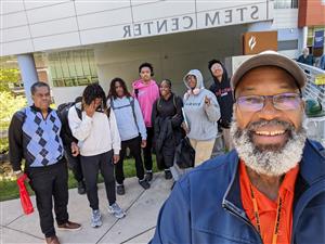 students and two teachers stand outside the stem center
