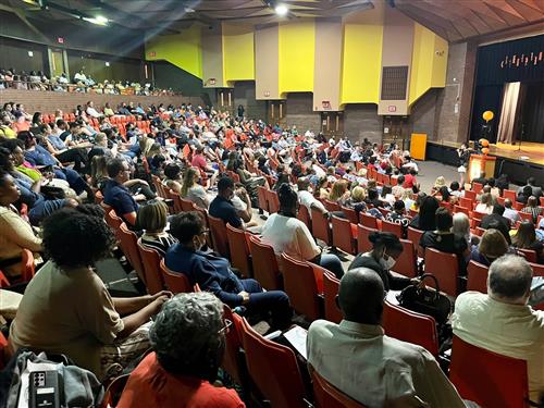 CUSD staff gather in the auditorium watching a speaker during convocation