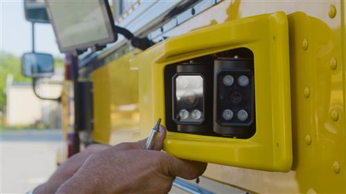 school bus camera being installed on a yellow school bus